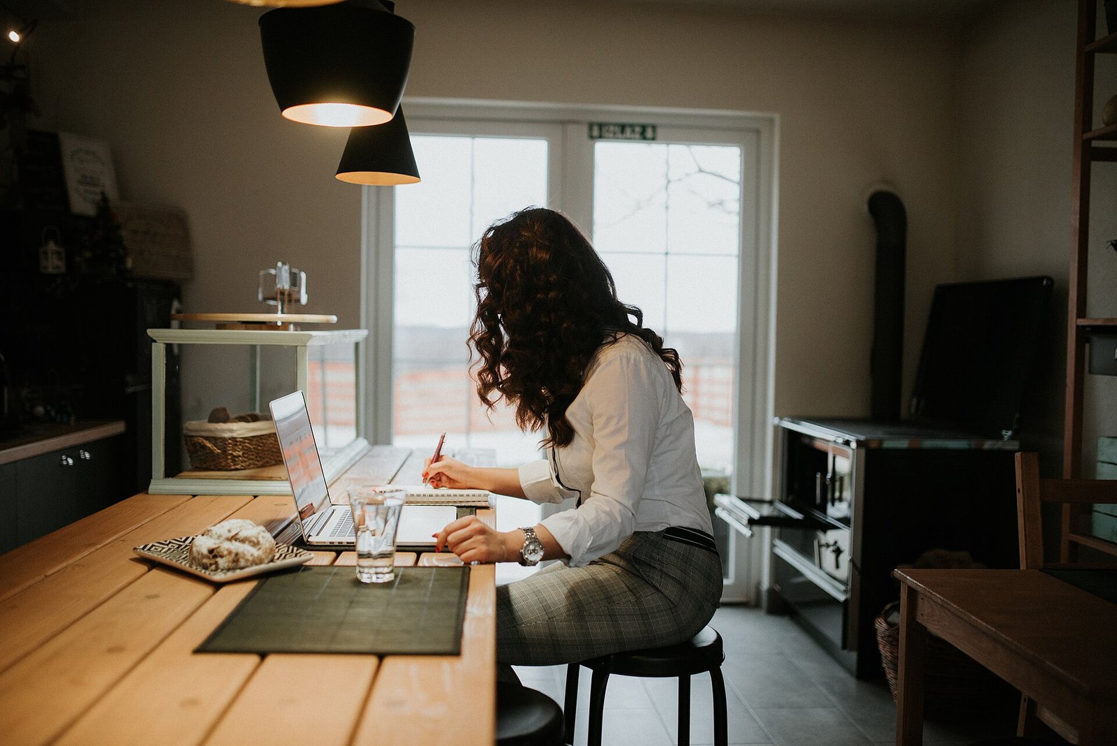 Person at a laptop handling paperwork