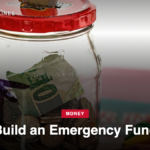 Glass savings jar with coins and a folded bill under a red lid