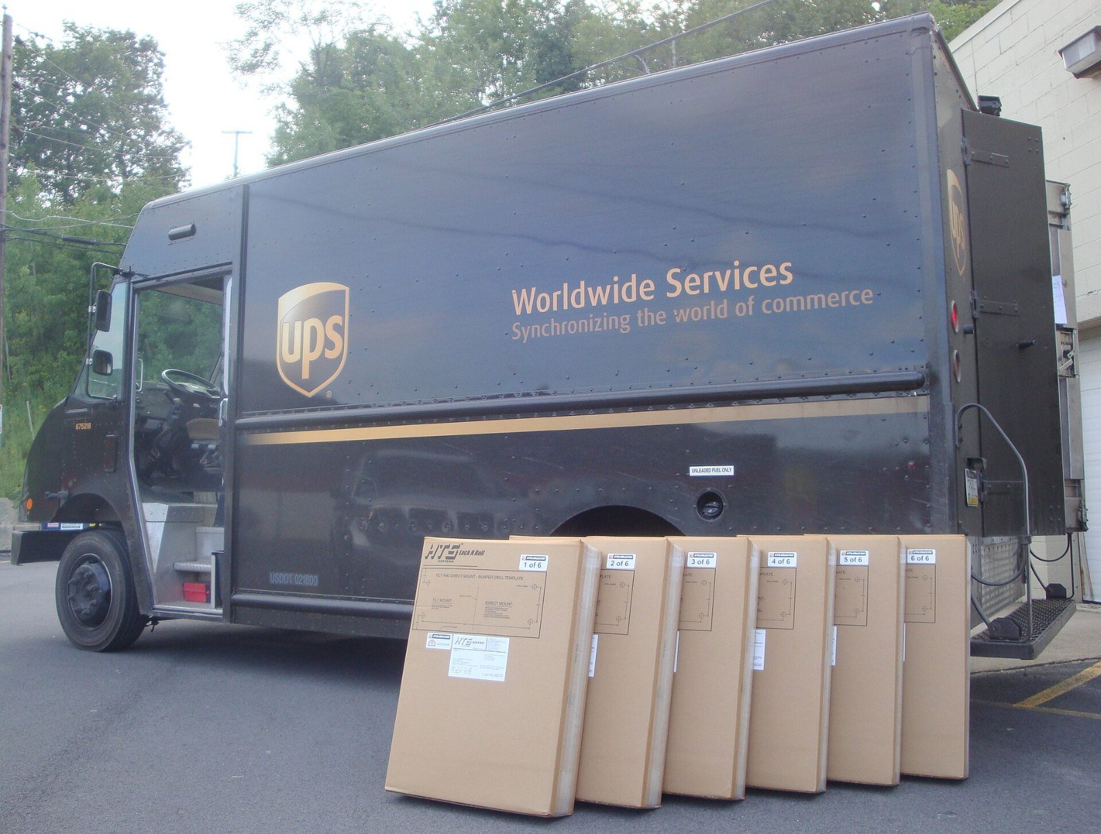 A brown UPS delivery truck with boxes stacked beside it