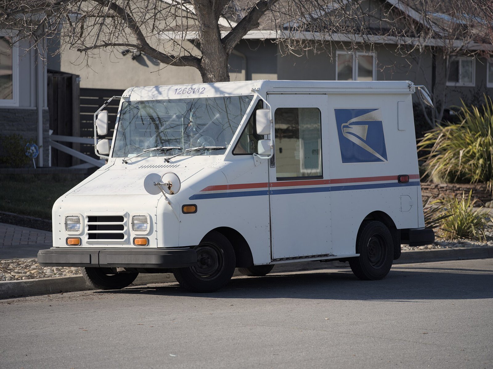 A white USPS mail delivery truck parked on a residential street