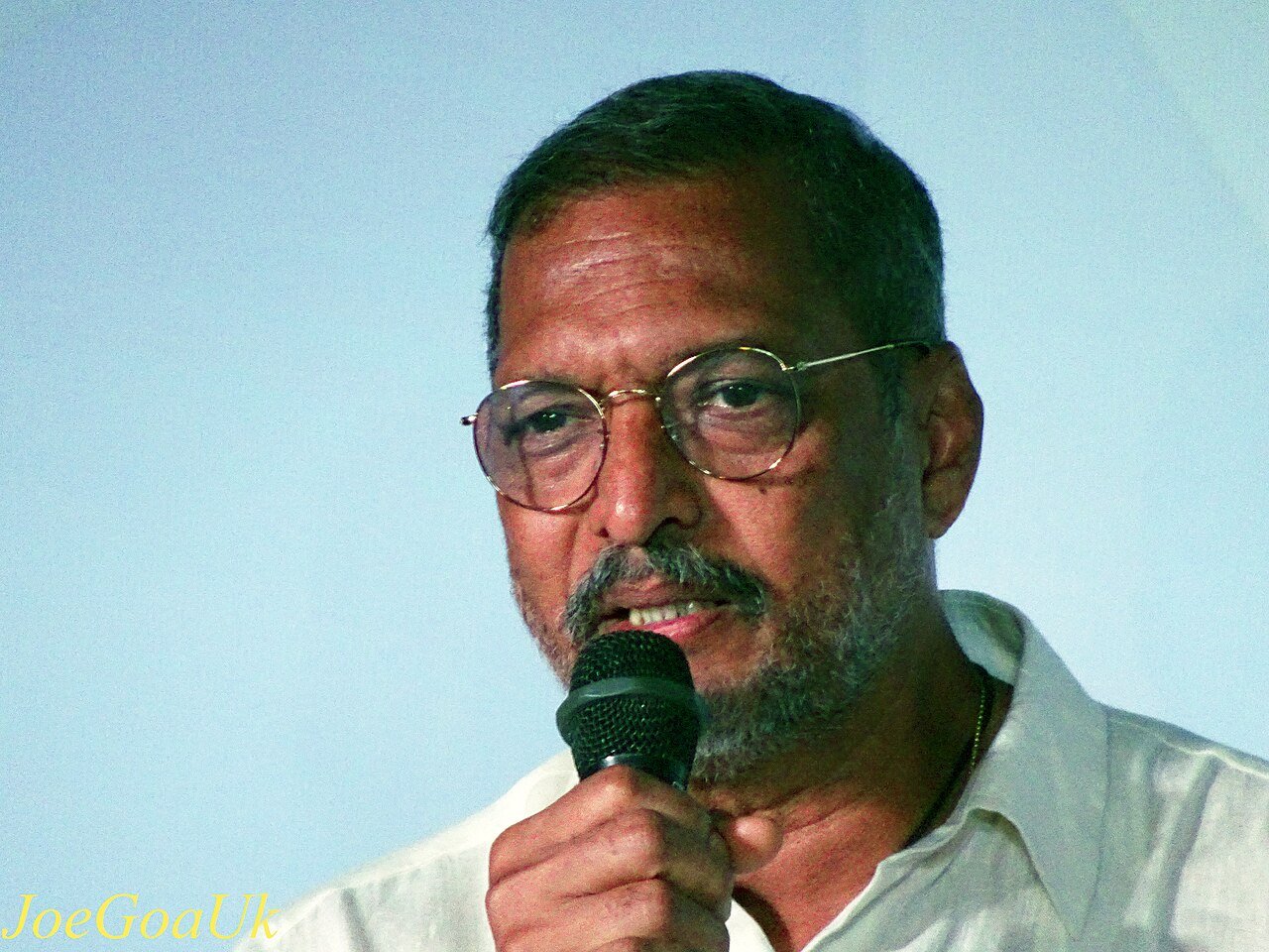 Nana Patekar speaking into a microphone at IFFI Goa in 2017