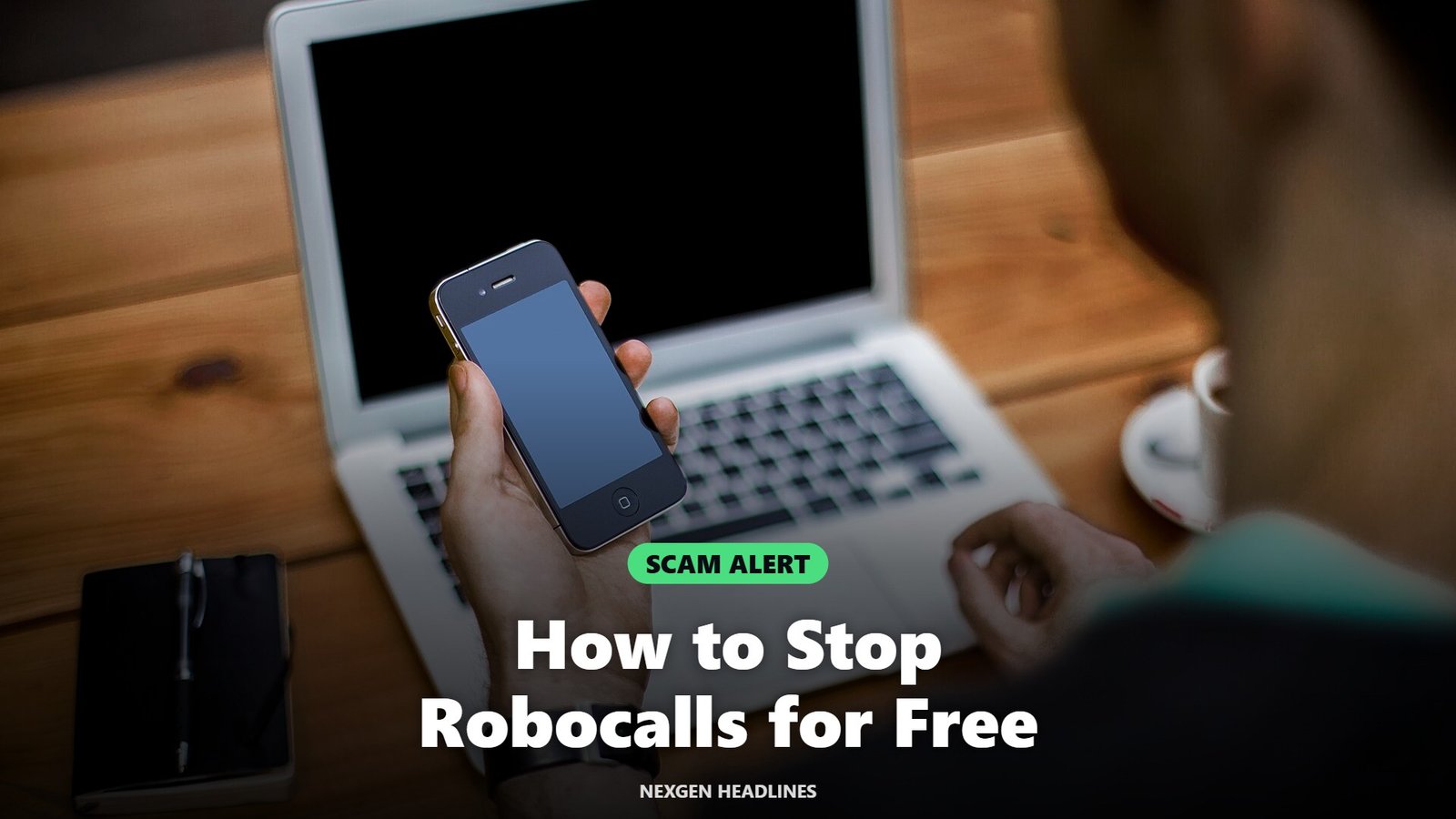 A man holding a smartphone at his desk