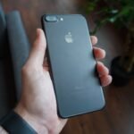 A hand holding a black smartphone