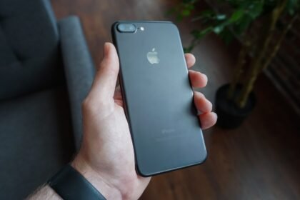 A hand holding a black smartphone