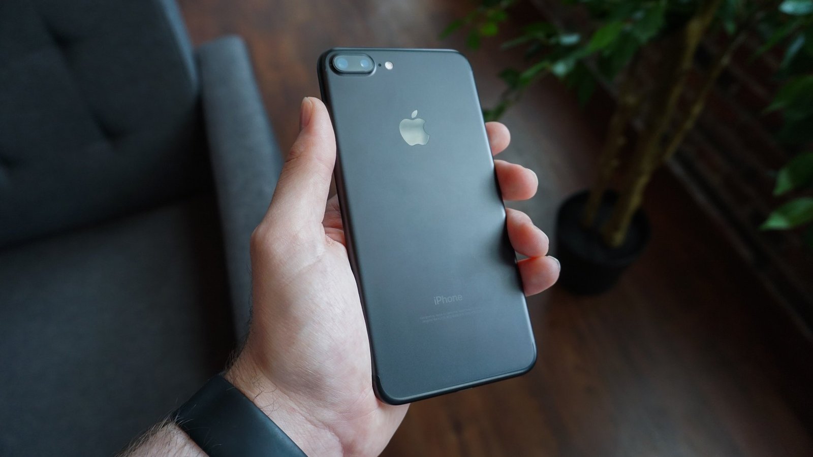 A hand holding a black smartphone