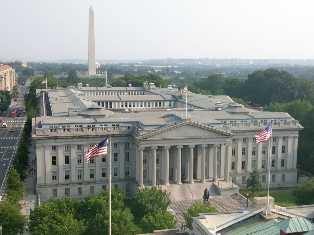Aerial view of the U.S. Treasury Building in Washington, D.C., with the Washington Monument behind it